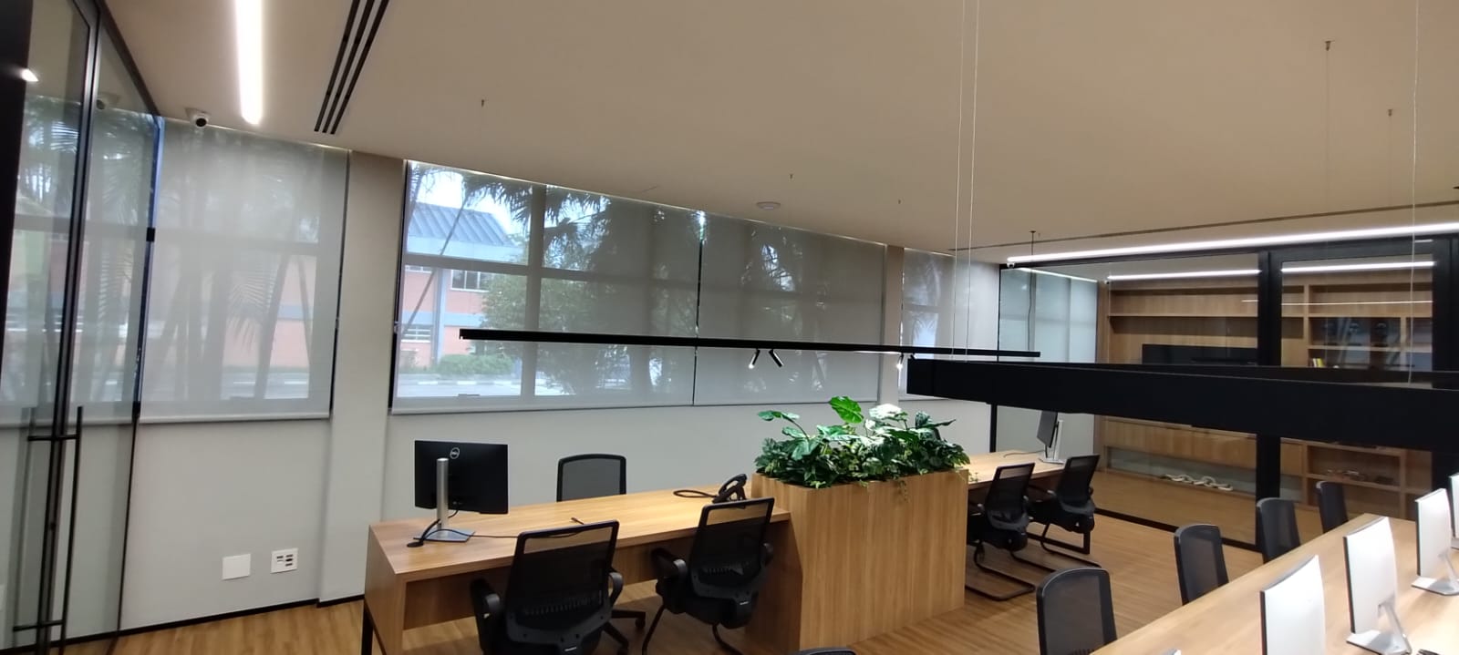 Workspace corporativo com persianas screen e iluminação integrada